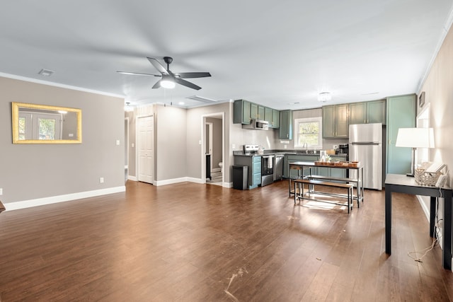 living room featuring crown molding, sink, ceiling fan, and dark wood-type flooring