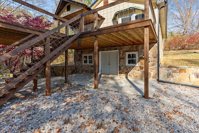 back of property with a wooden deck and a patio