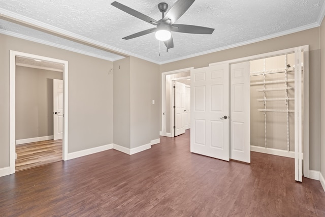 unfurnished bedroom with ceiling fan, dark hardwood / wood-style floors, ornamental molding, a textured ceiling, and a closet