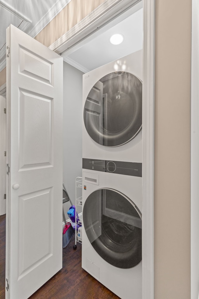 clothes washing area featuring dark hardwood / wood-style floors and stacked washer / drying machine