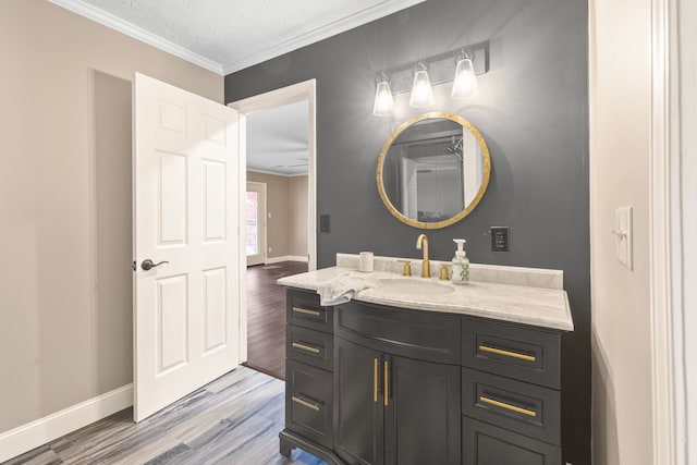 bathroom featuring hardwood / wood-style flooring, vanity, ornamental molding, and a textured ceiling