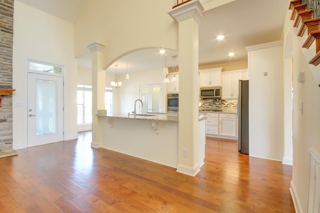 kitchen featuring sink, white cabinets, light wood-type flooring, and appliances with stainless steel finishes