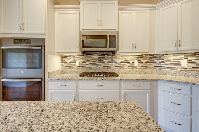 kitchen featuring white cabinetry, appliances with stainless steel finishes, and tasteful backsplash