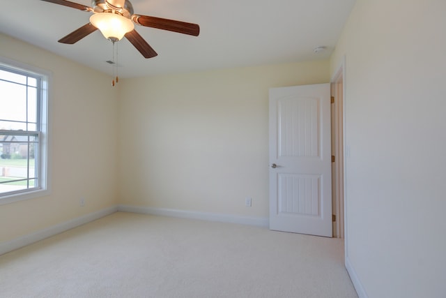 spare room featuring light carpet and ceiling fan