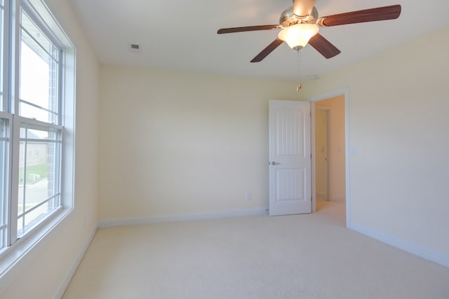 carpeted spare room featuring ceiling fan