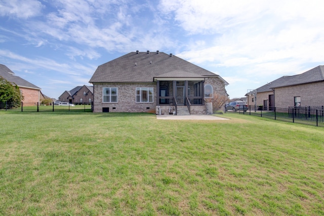 rear view of property featuring a patio area, a sunroom, and a yard