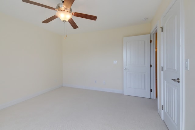 empty room featuring ceiling fan and light colored carpet