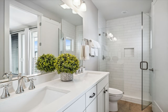 bathroom with tile patterned flooring, vanity, an enclosed shower, and toilet