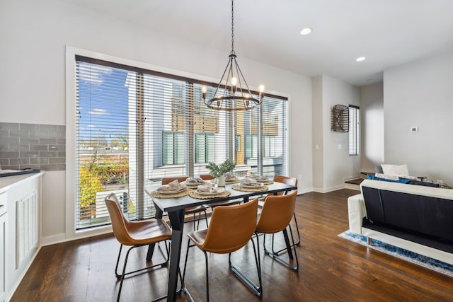 dining room with dark hardwood / wood-style floors and an inviting chandelier