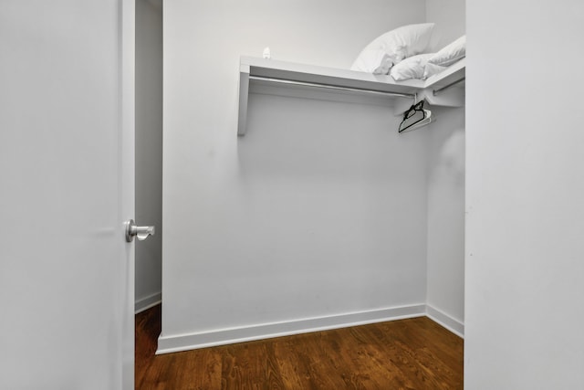 walk in closet with dark hardwood / wood-style flooring