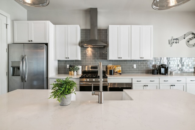 kitchen with backsplash, stainless steel appliances, white cabinetry, and wall chimney range hood