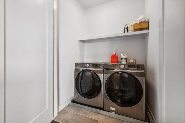 laundry area with washer and clothes dryer and light tile patterned floors