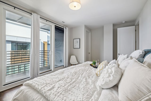 bedroom featuring access to exterior and dark hardwood / wood-style flooring