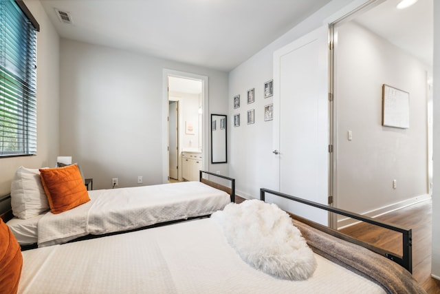 bedroom featuring wood-type flooring and connected bathroom