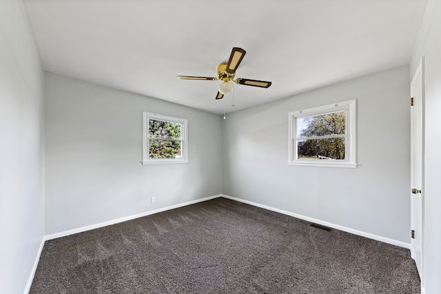 carpeted spare room featuring ceiling fan and a healthy amount of sunlight