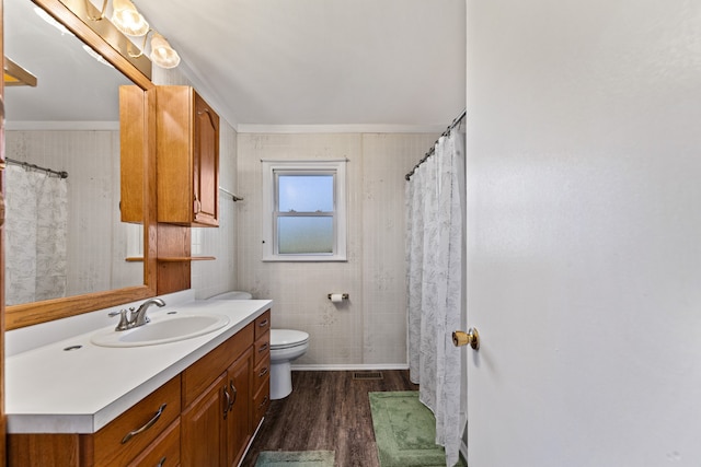 bathroom featuring toilet, hardwood / wood-style floors, vanity, and ornamental molding