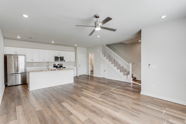 kitchen featuring white cabinets, light hardwood / wood-style floors, sink, and stainless steel appliances