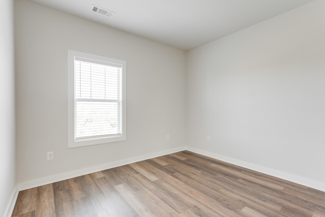 spare room featuring a wealth of natural light and wood-type flooring