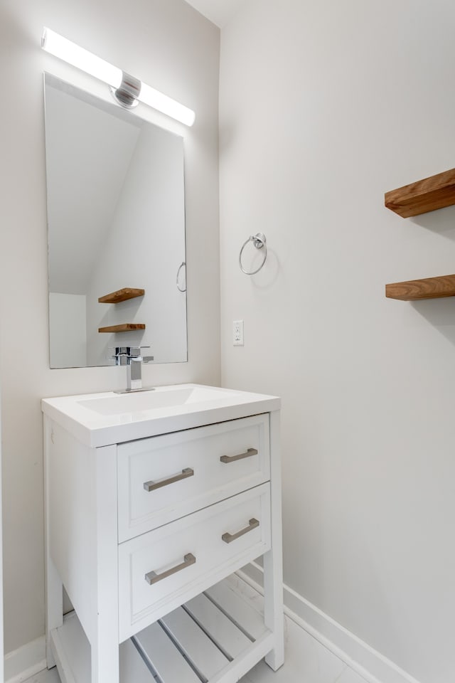 bathroom featuring tile patterned flooring, vanity, and vaulted ceiling