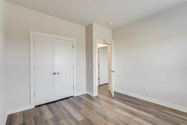 unfurnished bedroom with a closet and light hardwood / wood-style floors