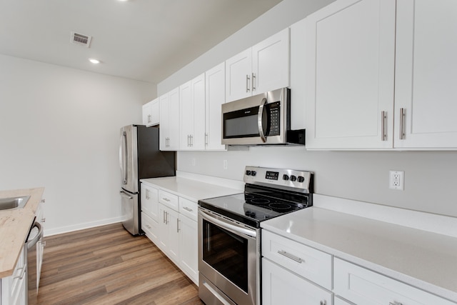 kitchen with white cabinetry, light wood-type flooring, and appliances with stainless steel finishes