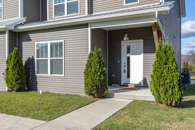 property entrance featuring a yard and central AC