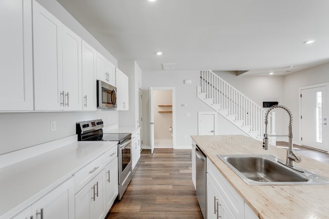 kitchen featuring dark hardwood / wood-style flooring, white cabinetry, sink, and stainless steel appliances