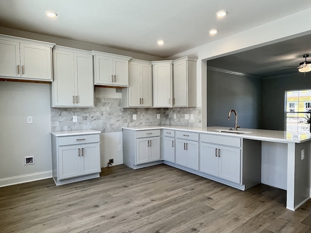 kitchen with white cabinetry, ceiling fan, sink, light hardwood / wood-style flooring, and crown molding