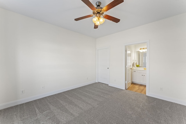 unfurnished bedroom featuring light colored carpet, ensuite bath, and ceiling fan