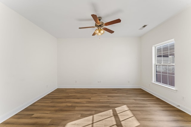 spare room with dark hardwood / wood-style flooring and ceiling fan