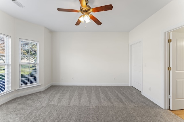 spare room with ceiling fan and light colored carpet