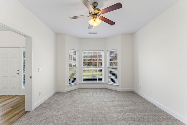 unfurnished room with ceiling fan and light carpet