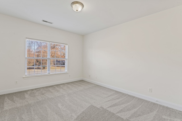 spare room featuring light carpet