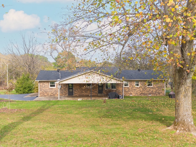 rear view of house featuring a patio area and a yard