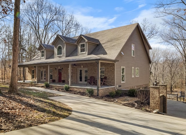 new england style home featuring covered porch and french doors