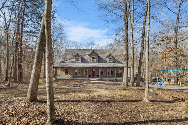 new england style home featuring a porch and a playground