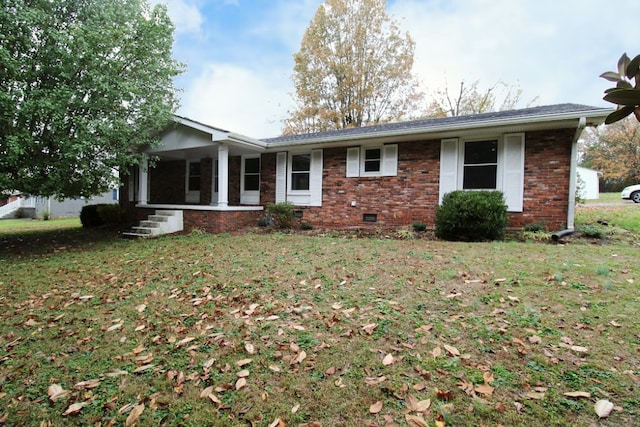 rear view of property featuring a lawn and a porch