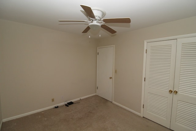 unfurnished bedroom featuring ceiling fan, light carpet, and a closet