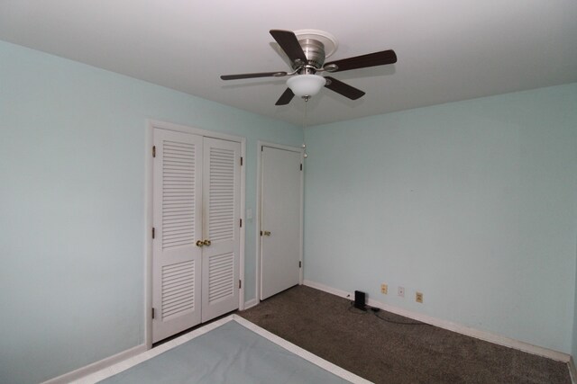 unfurnished bedroom featuring ceiling fan, a closet, and dark carpet