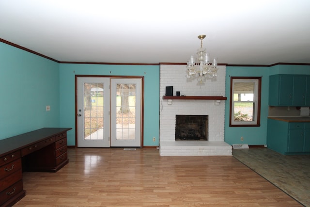 unfurnished living room with a chandelier, a fireplace, crown molding, and light hardwood / wood-style flooring