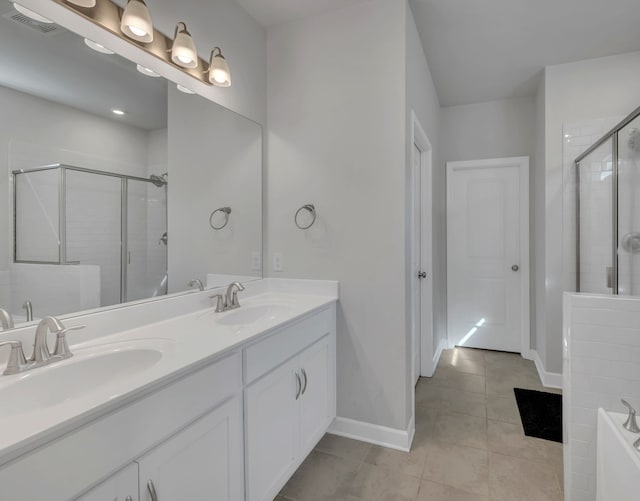 bathroom with tile patterned flooring, vanity, and walk in shower