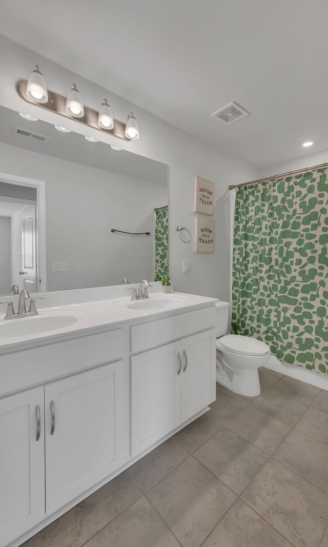 bathroom with a shower with curtain, vanity, toilet, and tile patterned floors