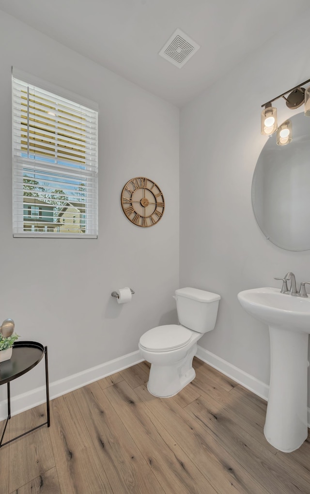 bathroom with hardwood / wood-style flooring, toilet, and sink