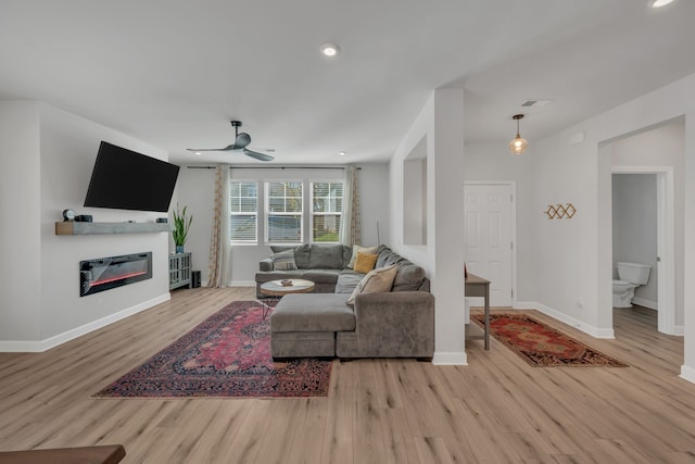 living room with ceiling fan and light hardwood / wood-style floors