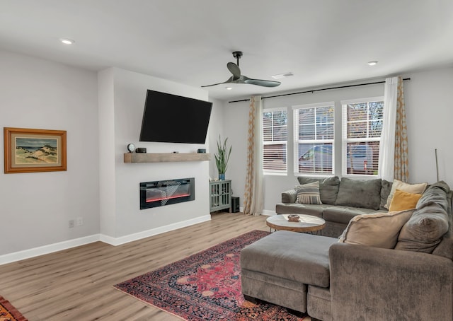 living room featuring hardwood / wood-style floors and ceiling fan