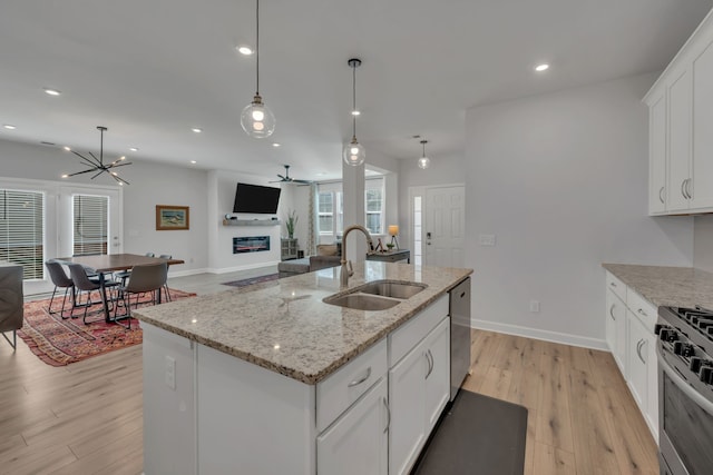 kitchen featuring a center island with sink, white cabinets, light hardwood / wood-style floors, and sink