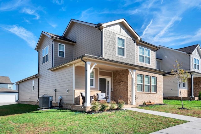 view of front facade with central AC unit, covered porch, and a front yard