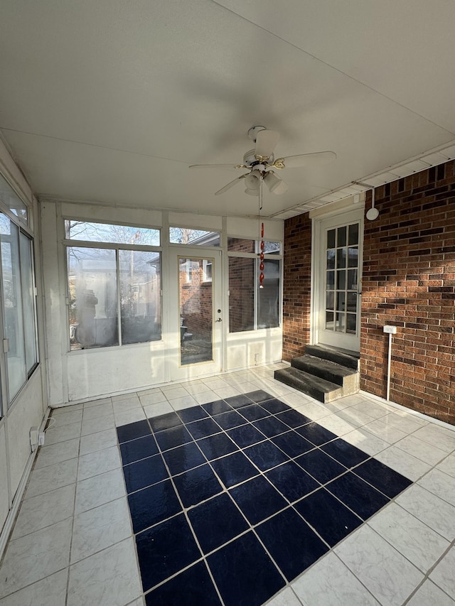 unfurnished sunroom featuring ceiling fan