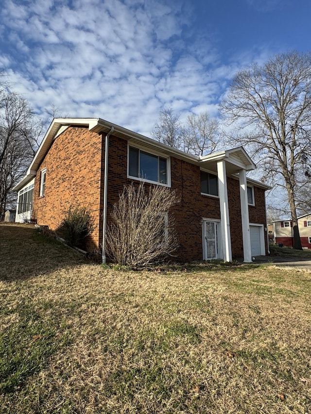 view of side of home featuring a lawn and a garage