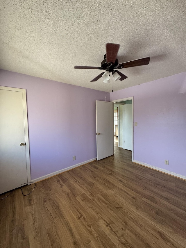 spare room featuring a textured ceiling, dark hardwood / wood-style floors, and ceiling fan